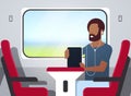 Man train passenger listening audio book with headphones african american guy sitting red armchair railway traveling