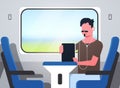 Man train passenger listening audio book with headphones stylish guy sitting blue armchair railway traveling concept