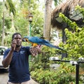 Man training the ara in Konoko Gardens, Jamaican