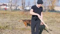 A man training his german shepherd dog - incite the dog on the grip bait and making the dog jump - a dog running in the