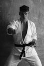 Man training karate in white kimono on beige background, sport Royalty Free Stock Photo