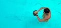 Man trains in pool. View from above on a ailetic male swimmer swimming in the blue clear water wearing goggles for Royalty Free Stock Photo