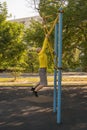 Man trains on a rock climbing machine on a street sports ground.