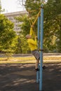 Man trains on a rock climbing machine on a street sports ground.