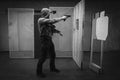 A man trains tactical shooting with a rifle and a pistol at a shooting range at a target. Black and white photo Royalty Free Stock Photo