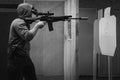 A man trains tactical shooting with a rifle and at a shooting range at a target. Black and white photo Royalty Free Stock Photo