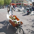 Man on transport bike with flowers in amsterdam