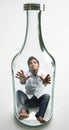 Man trapped inside of a bottle who is starting to deform from alcohol abuse as anti drinking concept Royalty Free Stock Photo