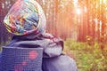 Man traveler close-up of back with a backpack in the forest with sunbeams. Toned