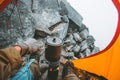 Man traveler cooking food in pot on stove burner in camping tent