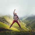 Man traveler jumps on background of mountain. Concept of outdoor adventure motivation wanderlust