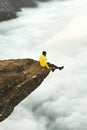 Man traveler meet the dawn sitting on Trolltunga Royalty Free Stock Photo