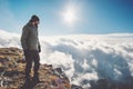 Man Traveler on mountain cliff over clouds