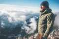 Man Traveler on mountain summit with clouds around