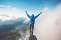 Man Traveler on mountain summit enjoying aerial view