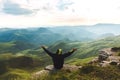 Man Traveler on mountain summit enjoying aerial view hands raised Travel Lifestyle success concept adventure active vacations Royalty Free Stock Photo