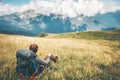 Man Traveler relaxing sitting on grass valley at mountains