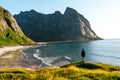 Man traveler on rocky enjoying beautiful mountain view and beach.