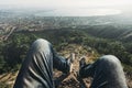 Man traveler sits on top and enjoys view of the picturesque landscape and the city. Point of view shot. Travel, adventure, tourism