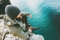 Man traveler sitting on cliff alone thinking above deep sea Royalty Free Stock Photo