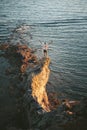 Man traveler standing on cliff edge rock above sea adventure travel lifestyle active vacations