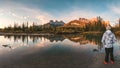 Man traveler standing enjoy the scenery of Three Sisters Mountains reflection on river in autumn at morning Royalty Free Stock Photo