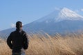 Man traveler standing and looking Beautiful Mount Fuji with snow capped and blue sky at Lake kawaguchiko, Japan Royalty Free Stock Photo