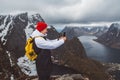 Man traveler taking photo with a smartphone hiking on Reinebringen mountain ridge in Norway lifestyle adventure traveling Royalty Free Stock Photo