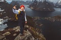 Man traveler taking self-portrait a photo with a smartphone hiking on Reinebringen mountain ridge in Norway lifestyle adventure Royalty Free Stock Photo