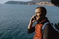 Man Traveler talking by phone on the background of the sea Royalty Free Stock Photo