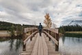 Man traveler walking cross over wooden bridge in autumn at Cascade Ponds, Banff national park Royalty Free Stock Photo