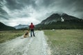 Man traveling with dog in Switzerland on rural road in mountains Royalty Free Stock Photo