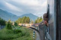 Man traveling by railway through Balkans. Handsome young guy looking out the train window. Tourist male traveller