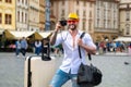 Man traveller with sunglasses, hat and camera. Business man on business trip walking with travel bag on city street Royalty Free Stock Photo