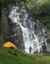 A man traveller walk togather Tent and camping with Mae Tia waterfall