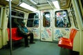 A man is travelling in a dirty and old metro wagon full of graffiti