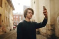 A man travels in Europe street. A man smiles, walks through the streets of the old city, with a briefcase. Student travels alone. Royalty Free Stock Photo