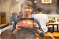 Man with tray of sliced beef