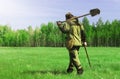 Man on a treasure hunt with a metal detector in the woods on the field