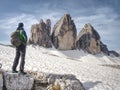 Man trekking in Alps. Sharp peaks stick over the clouds in a beautiful sunny day