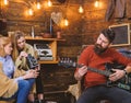 Man with trendy hipster beard composing song, music concept. Bearded man playing guitar. Family spending time listening Royalty Free Stock Photo