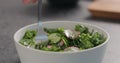 Man tries fresh salad with radish, cucumber and herbs in white bowl Royalty Free Stock Photo