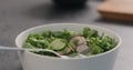 Man tries fresh salad with radish, cucumber and herbs in white bowl Royalty Free Stock Photo