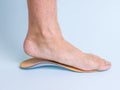 The man tries on the left foot orthopedic insole. Means for the treatment of flat feet. Royalty Free Stock Photo