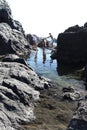 Man tries to help woman across water as a girl walks between them in Tenerife, Spain