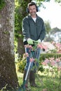 man with trimer mows grass in courtyard Royalty Free Stock Photo