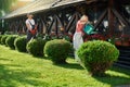 Man trimming bushes while woman watering flowers Royalty Free Stock Photo