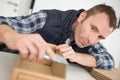 man trimming edge cardboard container with sharp knife