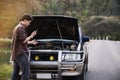 Man try to fix a car engine problem on a local road Chiang mai Thailand