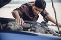 Man try to fix a car engine problem on a local road Chiang mai Thailand